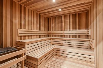A wooden sauna with benches and a table.